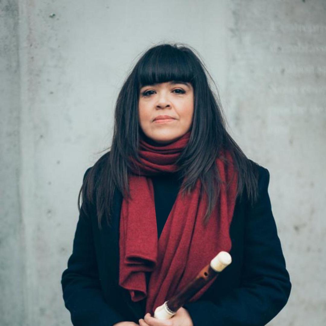 Portrait of Violeta Motta with her traverso: three-quarter view, holding the wooden flute at chest level