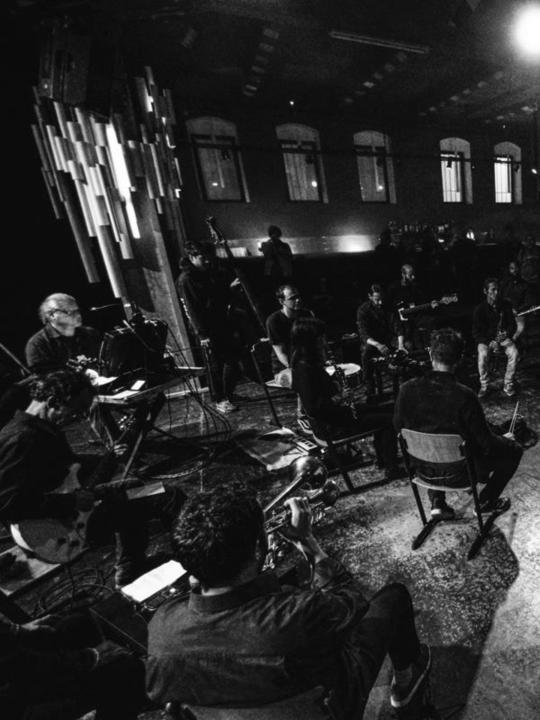 The Insub. Meta Orchestra performing: live ensemble footage with multiple musicians, black and white