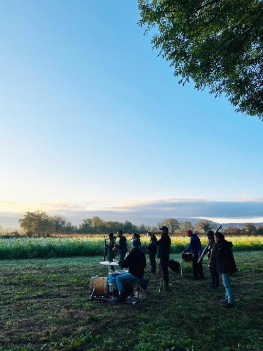 Insub. Polytopies musicians with their instruments looking toward the setting sun