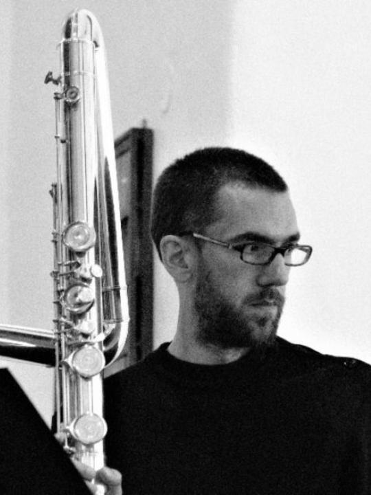 Portrait of Sylvain Monchocé with his contrabass flute: black and white
