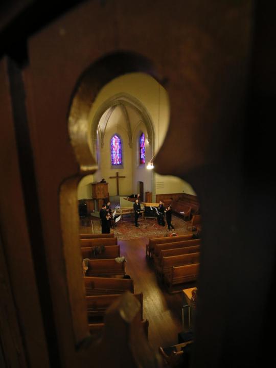 A Cocyte project performance: musicians seen through an architectural element of a church